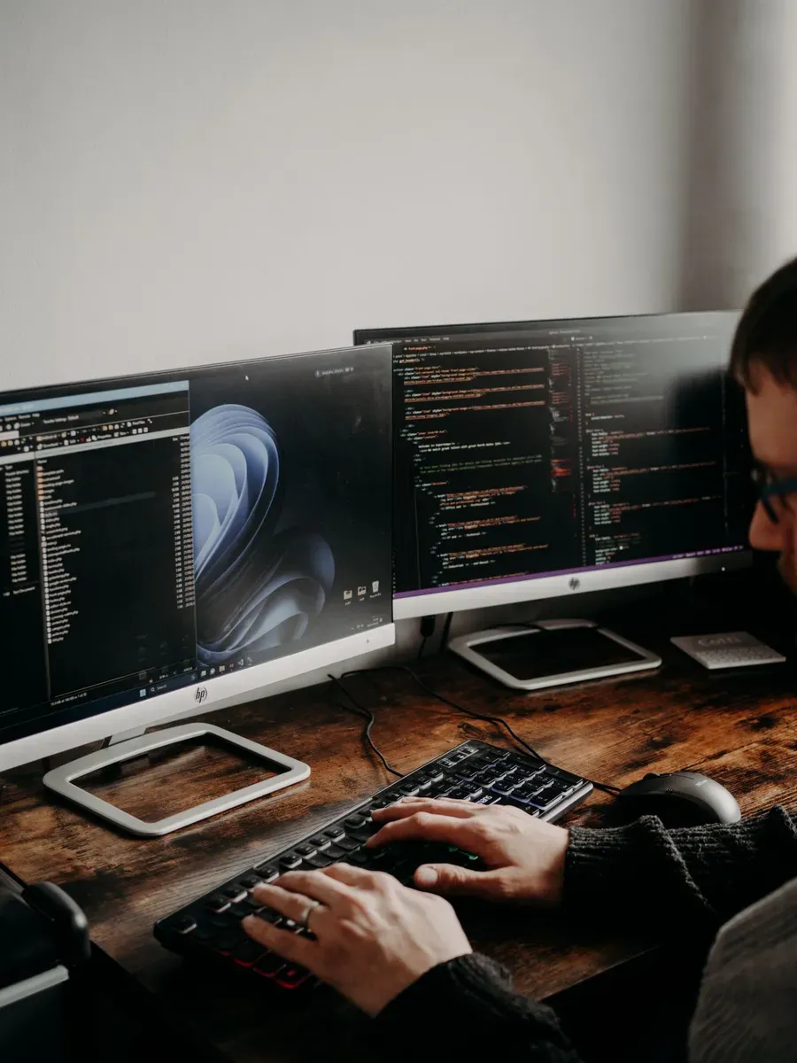 Ecrã com o código HTML de uma landing page a ser escrito à mão, num ambiente de programação.